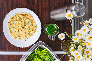 Still life of food on the table, flat lay. Bread Flatbread with herbs and mint tea. Natural products