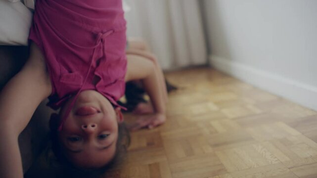 Sisters with tongue out doing handstands