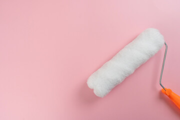 close up brush paint roller on the pink background house, diy and repair concept