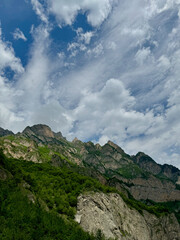 Sharp peaks of the Caucasus mountains against the background of a cloudy sky in Vladikavkaz, Russia