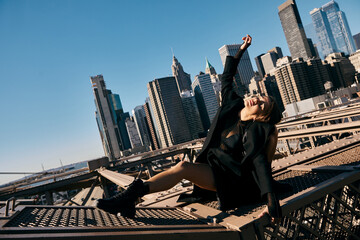 A young woman dances on a bridge in New York City.