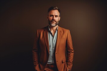 Fototapeta premium Portrait of a content man in his 40s dressed in a stylish blazer while standing against light wood minimalistic setup