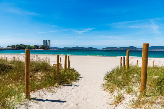 Fenced path over fine sand dunes on O Vao beach, Corujo parish, with views of the island of Toralla, in the Vigo estuary, Pontevedra.