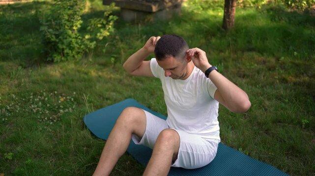  man performs somatic exercises in the garden in the morning