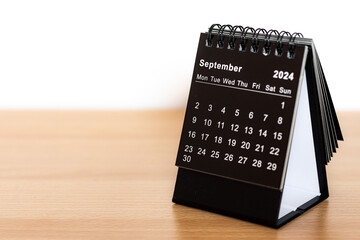September 2024 black calendar - month page on the wooden desk