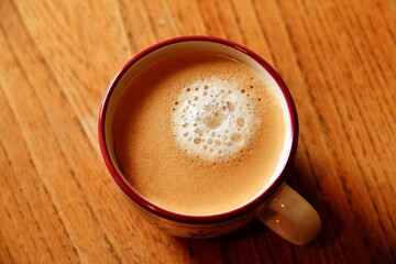 A cup of coffee on a wooden table.