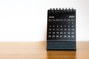 June 2024 black calendar - month page on the wooden desk