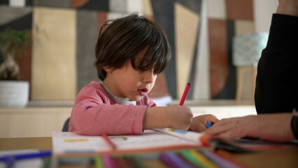 Child and parent working together on a colorful workbook, emphasizing the importance of collaborative learning and parental guidance in a home setting