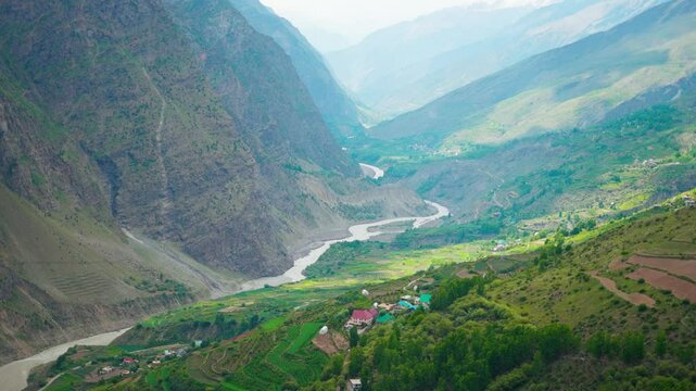 4K Landscape shot of River Chenab flowing between the two Himalayan mountains as seen from Marbal Village in Lahaul, Himachal Pradesh, India. Chandra Bhaga river flows between the mountain valley.