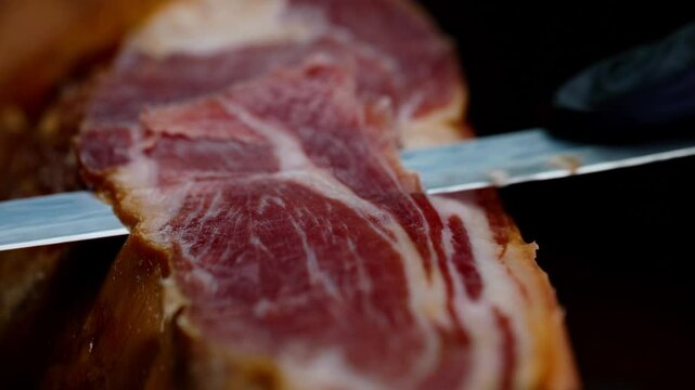 Chef cutting dry-cured spanish ham Jamon.