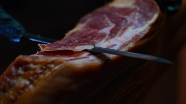 Chef cutting dry-cured spanish ham Jamon.