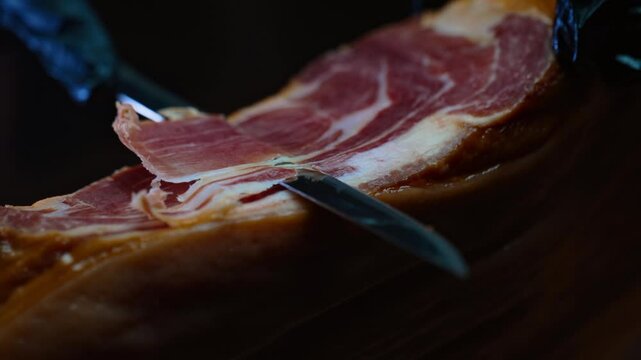 Chef cutting dry-cured spanish ham Jamon.