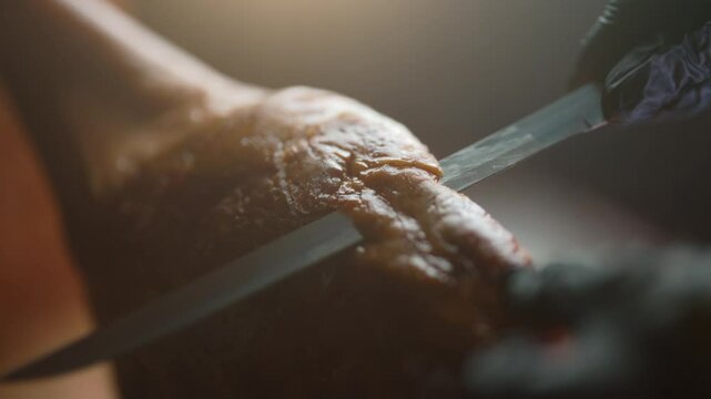 Chef cutting dry-cured spanish ham Jamon.