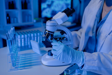 scientist is using microscope in laboratory, chemical researcher works in chemistry with...