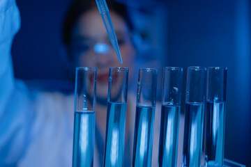 scientist is working on an important liquid inside tube in laboratory, the discovery of a vaccine to protect against currently spreading virus has been discovered, wear gloves and goggles for safety