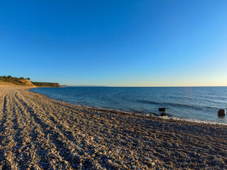 Waves raiding on a sandy shore. Wave of the sea on the sand beach. Beautiful turquoise sea and a wild beach. Beautiful sunset on the water. waves roll ashore in small pebbles
