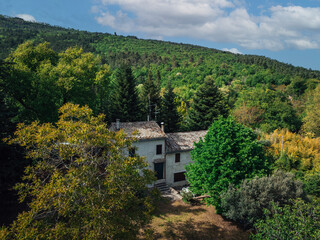 Aerial View of a White Farmhouse in a Wooded Area