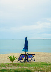 Beach bed ,canvas beds or trampoline with umbrellas in sea beach for tourists to rest on summer holiday with bright blue sky background at tropical island,Thailand.