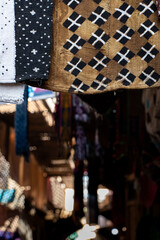 a patterned fabric hanging in a moroccan store with a blurry backgroung