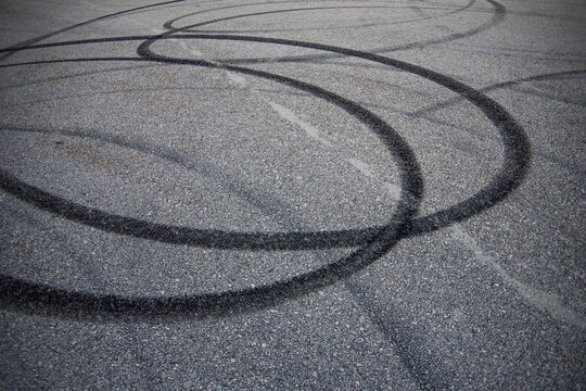 an asphalt road with black skid marks from drifting a car
