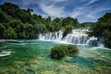 Fototapeta premium Waterfall among the green summer forest.