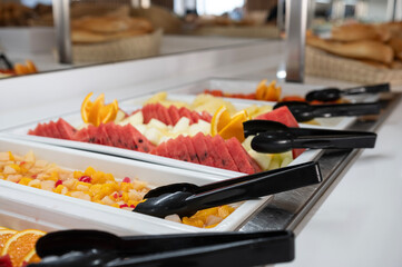 Bandejas de comida preparada en un bufet de un restaurante. Fruta variada para desayuno. 