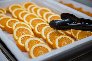Bandeja con lonchas de naranja preparada para el desayuno de un restaurante. 