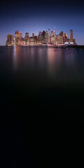Manhattan skyline on the horizon on dark blue and vignette background, with copy space at the...