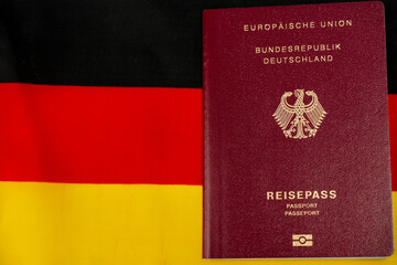 Passport with the inscription Reisepass. German citizen passport. It is located on top of the German flag.