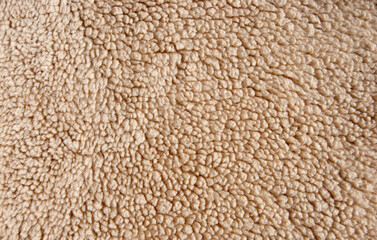 Fur texture. Beige fabric background. Furry texture in beige.