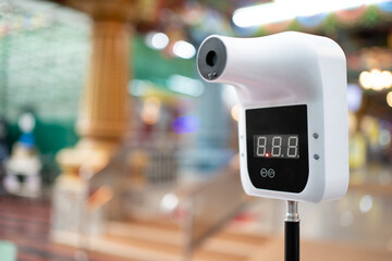 A digital, smart, non-contact, hands-free forehead infrared thermometer with a blurred background.