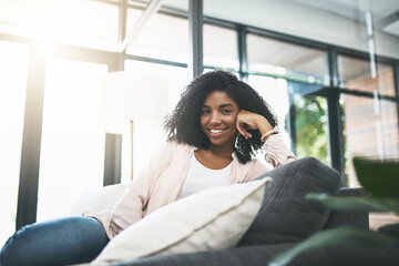 Fototapeta premium Living room, smile and portrait of woman on sofa for comfortable, rest and break on weekend. Female person, relax and calm with stress relief at home for happiness, satisfaction and confidence