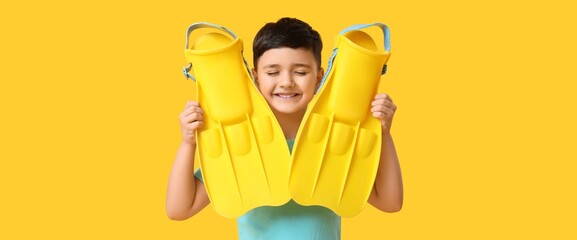 Happy little boy with flippers on yellow background © Pixel-Shot