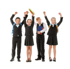 Obraz premium Little classmates in stylish uniform with backpacks and notebooks on white background