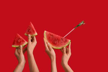 Female hands with slices of ripe watermelon and straw on red background