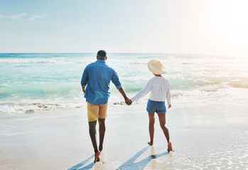 Water, love and couple with holding hands at beach for outdoor adventure, travel and holiday together. Man, woman and walking with back by ocean for anniversary, support and summer vacation in Cancun