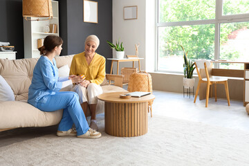 Mature woman after chemotherapy taking bottle of weed from doctor at home