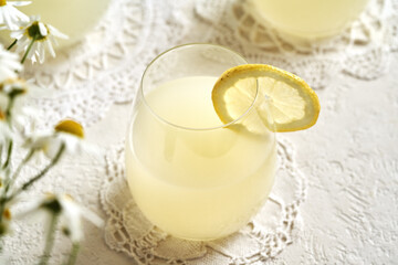 Natural whey in a glass cup with a slice of lemon