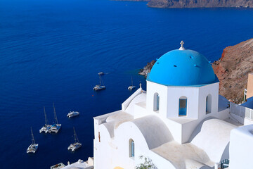 Oia, Santorini - Greece : Blue-domed church and lime-washed walls overlooking the beautiful...