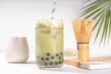 Green matcha boba bubble tea with tapioca pearl. Trendy asian cold iced drink with dark tapioca balls and non-dairy whipped creamed, copy space