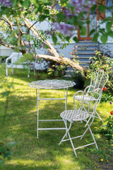 White metal patio furniture in a summer garden