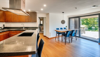 Interior of modern spacious kitchen with built in appliances and dining zone 
