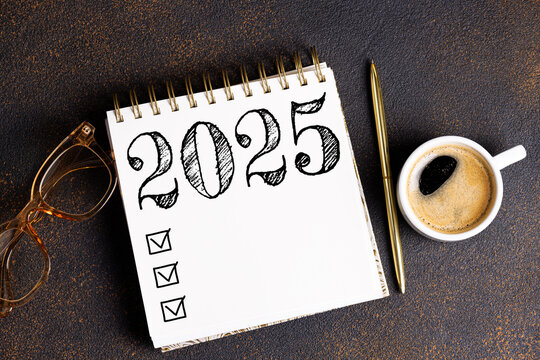 New year resolutions 2025 on desk. 2025 goals list with notebook, coffee cup, plant on desk. Resolutions, plan, goals, action, checklist, idea concept. New Year 2025 resolutions, copy space