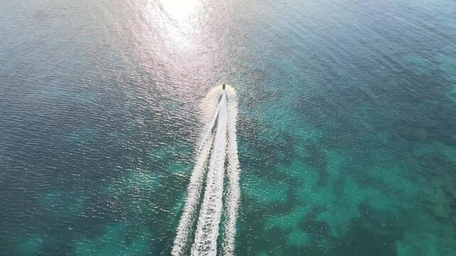 Drone shot of a jetski speeding off into the sunset in Vieques, Puerto Rico
