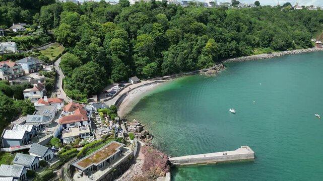 Babbacombe, South Devon, England: DRONE VIEWS: The drone flies over Babbacombe harbour wall towards the beach and past luxury apartments. Babbacombe is a popular UK holiday destination (Clip 4).