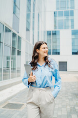 One beautiful young successful business woman going to work at business office modern building while holding laptop and wearing glasses	