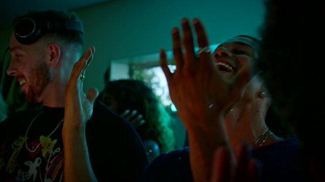 Man sings along to a song while dancing with friends at a house party