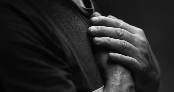 Heartfelt Senior Man with Hands on Chest in Quiet Reflection, Feeling Grateful in God's Grace in dramatic black and white