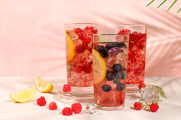 Detox water with fruit flavor on a light background. Refreshing summer homemade lemonade cocktail, mojito with raspberries, currants, mint and lemon, weight loss concept, healthy and natural food, 