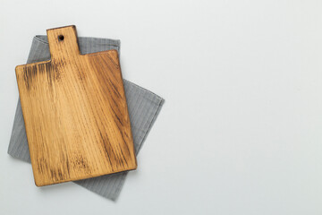 Cutting board with napkin on color background, top view